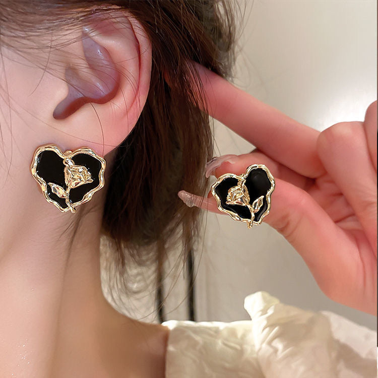 Aretes de corazones negros con flor dorada