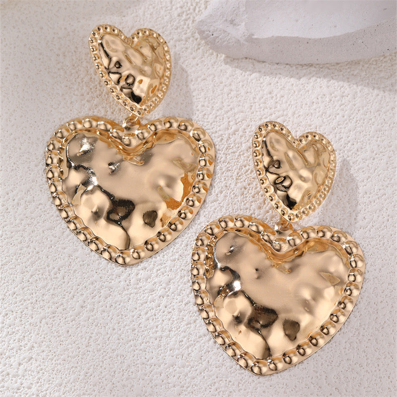 Aretes de corazones dorados con textura