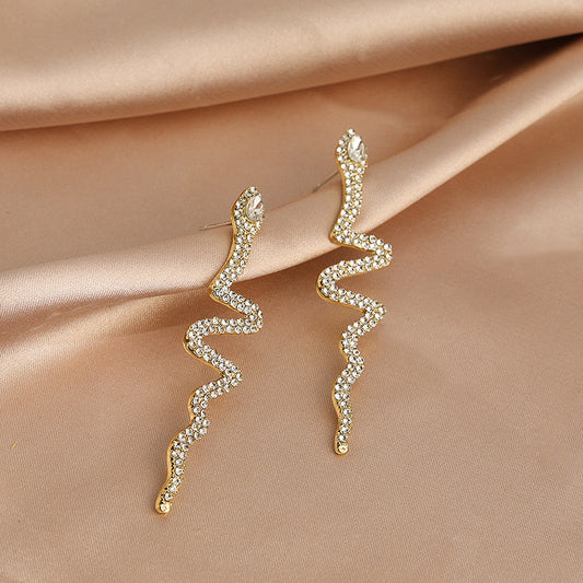 Aretes de serpientes doradas con pedrería plateada