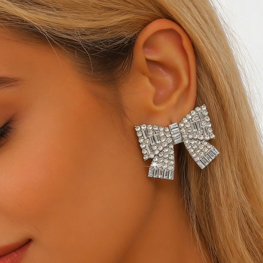 Aretes de moños plateados con pedrería