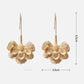 Aretes largos de flores doradas