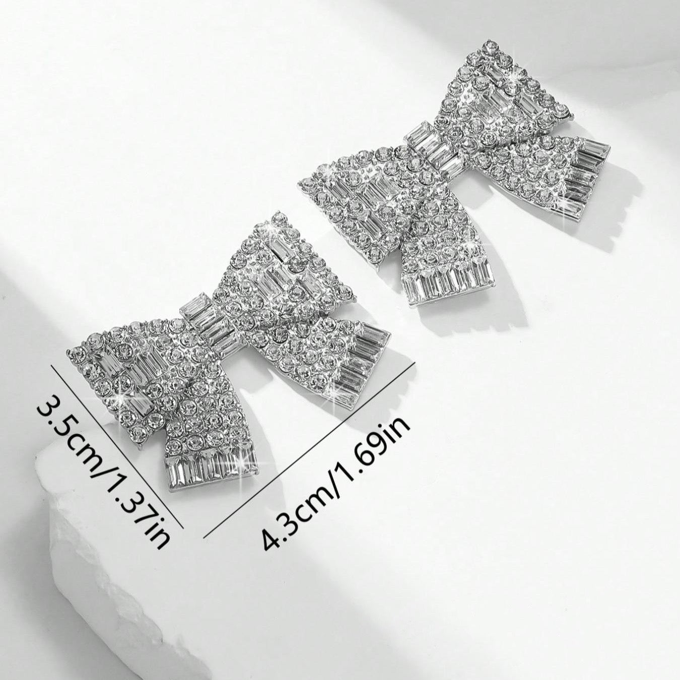 Aretes de moños plateados con pedrería
