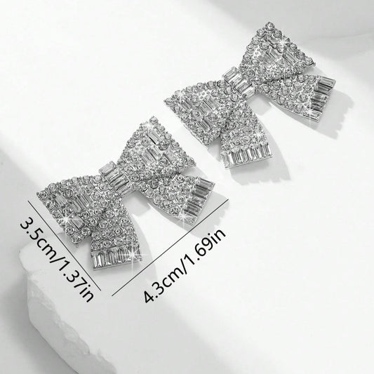Aretes de moños plateados con pedrería