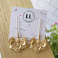 Aretes largos de flores doradas